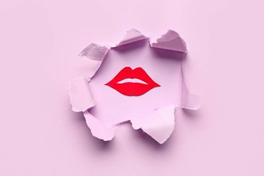 Pembe kağıttaki delikten görünen kırmızı kağıt dudaklar.