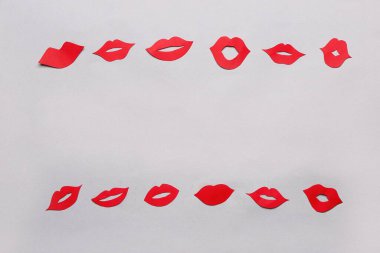 Işık arkaplanındaki kırmızı kağıt dudaklardan yapılmış çerçeve