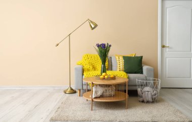 Gri kanepesi, masası ve lambası olan oturma odasının içinde.