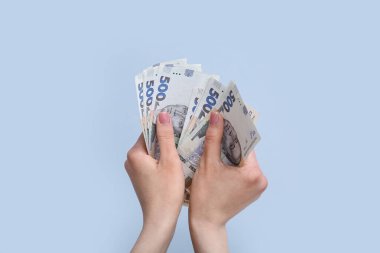 Gri arkaplanda Hryvnia banknotları olan bir kadın