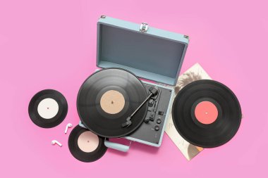 Pembe arka planda vinil diskleri olan kayıt çalar