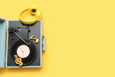 Sarı arka planda plak çalar, nota işaretleri ve kulaklık
