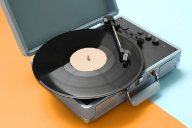 Renk arkaplanında vinil diski olan kayıt oynatıcı, kapat