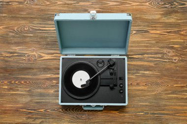 Ahşap arkaplanda vinil diski olan kayıt çalar