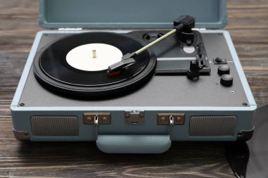 Koyu ahşap arka planda vinil diski olan kayıt çalar, yakın plan