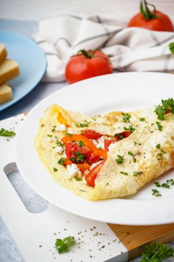 Domatesli omlet ve ışık masasında maydanoz.