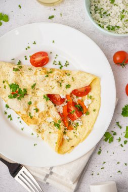 Domatesli omlet ve ışık masasında maydanoz.