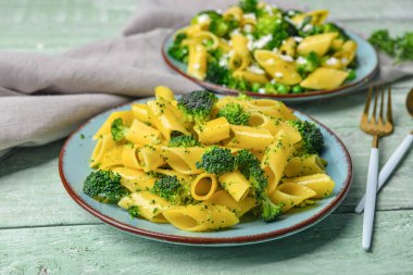 Lezzetli makarna ve yeşil ahşap arka planda brokoli.