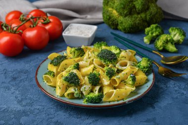 Lezzetli makarna ve mavi arka planda brokoli.