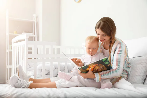 Young Mother Reading Book Her Cute Little Baby Bed — Stock Photo, Image