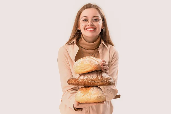 Młoda Kobieta Bochenkami Świeżego Chleba Jasnym Tle — Zdjęcie stockowe