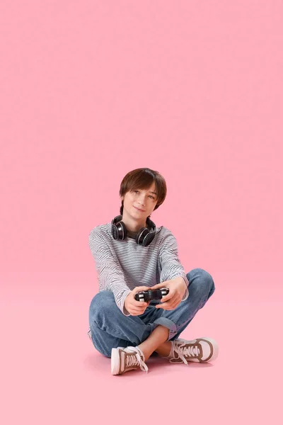 분홍색 배경으로 헤드폰을 비디오 게임을 — 스톡 사진