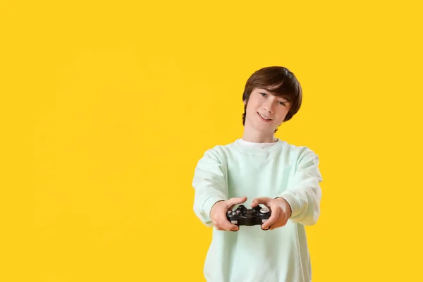 十代の男の子とともにゲームパッド上の黄色の背景 — ストック写真