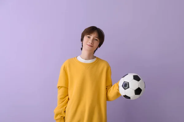 在紫丁香背景下带足球的十几岁男孩 — 图库照片