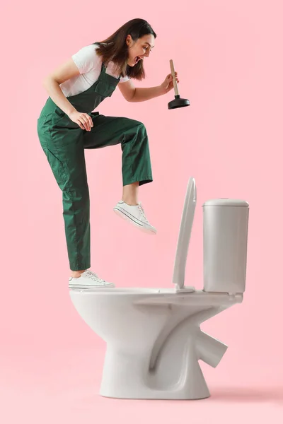 Zabawna Kobieta Hydraulik Tłokiem Muszlą Klozetową Różowym Tle — Zdjęcie stockowe