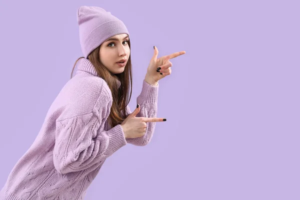 Pretty Young Woman Knitted Sweater Hat Pointing Something Lilac Background — Stock Photo, Image