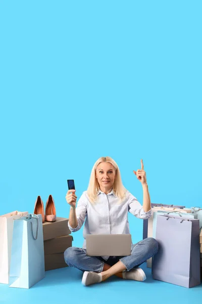 Volwassen Vrouw Met Laptop Creditcard Wijst Naar Iets Blauwe Achtergrond — Stockfoto