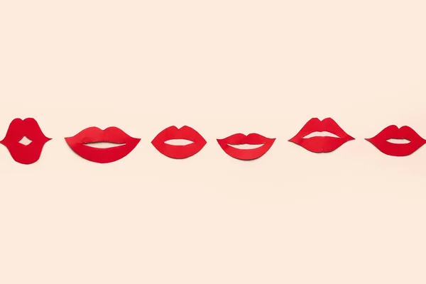 Red paper lips on beige background