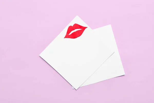 Blank paper sheets with red lips on pink background