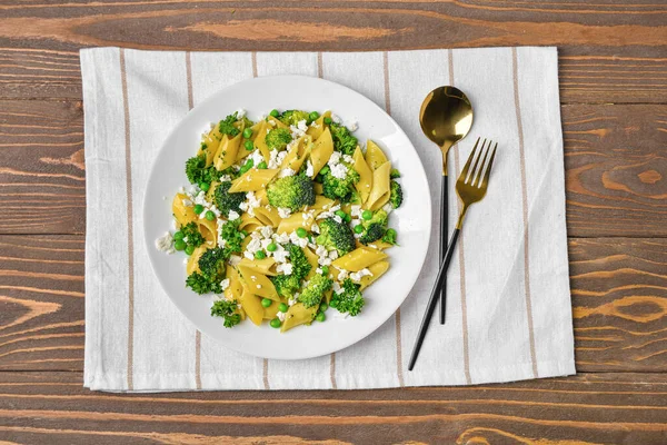 stock image Plate with tasty penne pasta and broccoli on wooden background