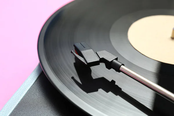 レコードプレーヤーピンクの背景にビニールディスク クローズアップ — ストック写真