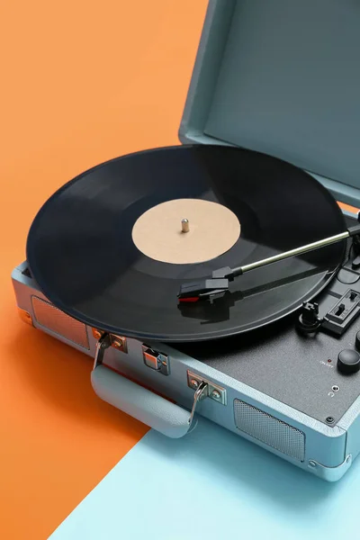 Record player with vinyl disk on color background, closeup