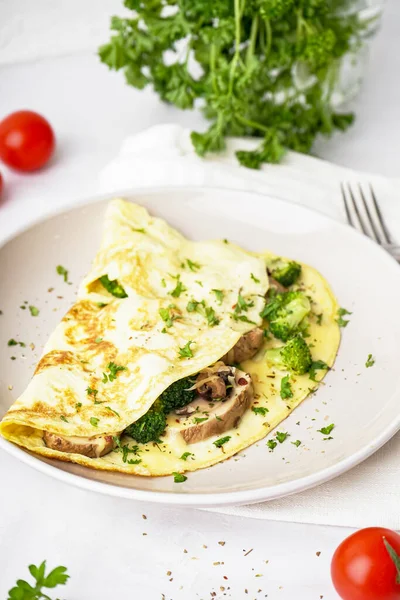 stock image Tasty omelet with broccoli and mushrooms on light table