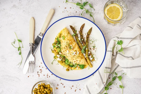 stock image Tasty omelet with broccoli, asparagus and pea on light table