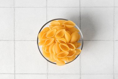 Beyaz kaplama üzerinde çiğ koni makarna ile kase