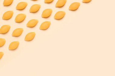 Sarı arkaplanda çiğ konchiglie makarna