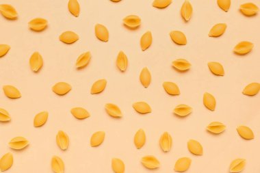 Sarı arkaplanda çiğ konchiglie makarna