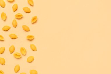 Sarı arkaplanda çiğ konchiglie makarna