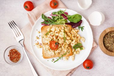 Yağda yumurtalı sandviç ve açık arkaplanda salata.