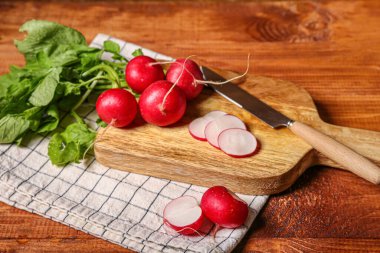 Ahşap zemin üzerinde yeşil yapraklar olan olgun turp tahtası.