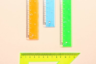 Renkli üçgen ve bej arkaplanda düz plastik cetvel