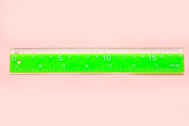 Pembe arka planda yeşil plastik cetvel