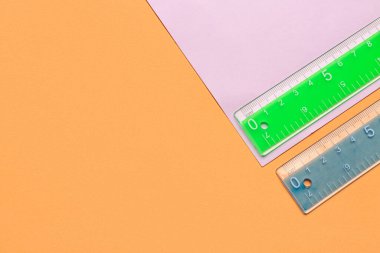 Renkli arkaplanda yeşil ve mavi plastik cetveller