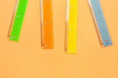 Turuncu arka planda renkli plastik cetveller