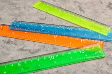 Gri grunge arka planında renkli plastik cetveller