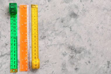 Gri grunge arkaplanda renkli mezuralar ve plastik cetvel