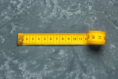 Koyu grunge arkaplanındaki sarı mezura