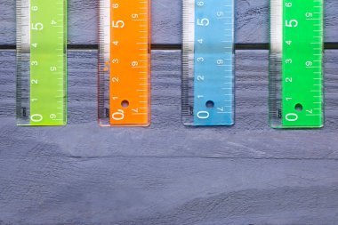 Mavi ahşap arka planda renkli plastik cetveller