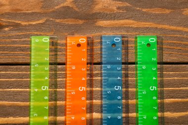 Ahşap arka planda renkli plastik cetveller