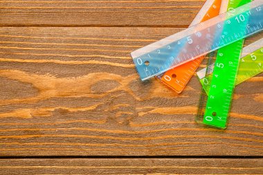 Ahşap arka planda renkli plastik cetveller