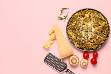 Pembe arka planda parmesan peynirli lezzetli İtalyan makarnası.