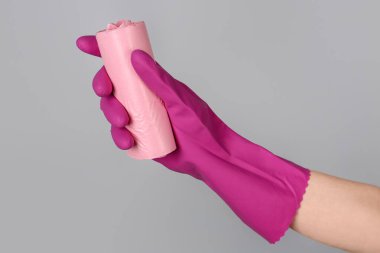 Gri arka planda çöp torbaları olan kauçuk eldiven verin.