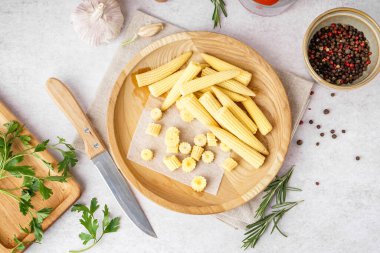 Açık arkaplanda kesilmiş bir tabak ve konserve mısır koçanı.