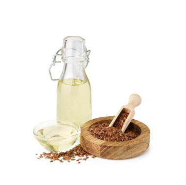 Beyaz arka planda keten yağı ve tohumlarla dolu şişe ve kase.