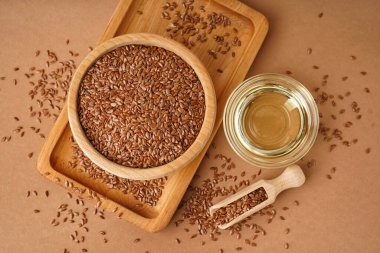 Kahverengi arka planda keten yağı ve tohumlu kase