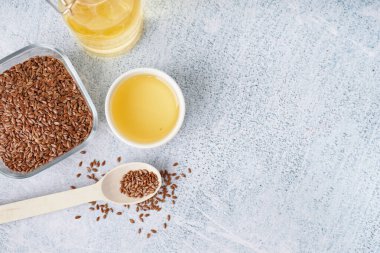 Keten tohumlu kaşık ve hafif arkaplanda bir kase yağ.